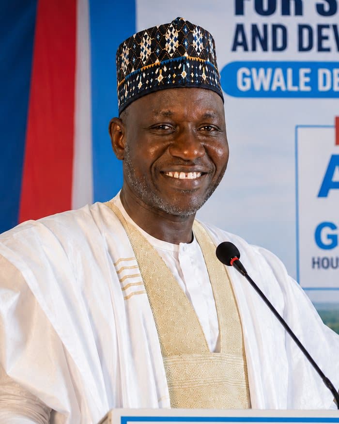 Dr. Bashir Aliyu, smiling, in a white gown and embroidered cap